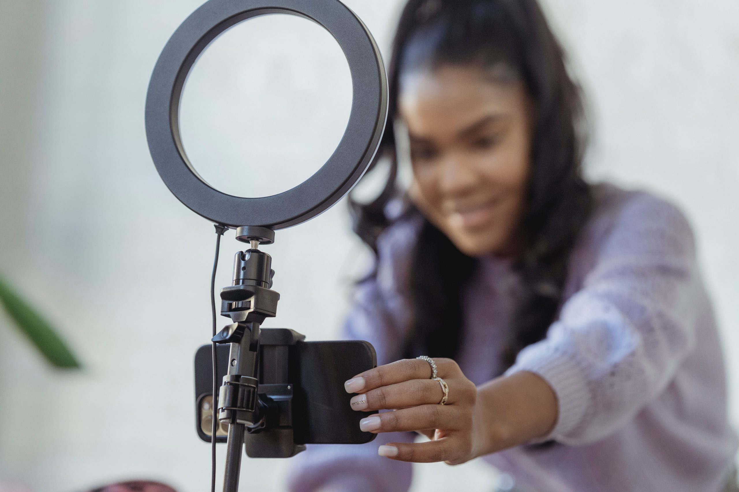 Woman adjusting cameral mounted on ring light
